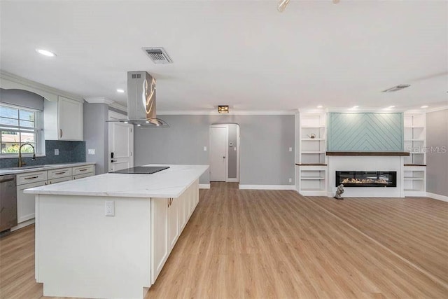 6989 300 Th Ave N, Clearwater, FL 33761 - kitchen with island range hood, a sink, a center island, light wood-type flooring, and ornamental molding