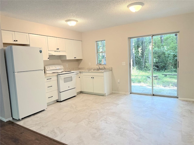 11751 Key Lime Dr, New Port Richey, FL 34654 - kitchen with white appliances, under cabinet range hood, white cabinetry, and a textured ceiling