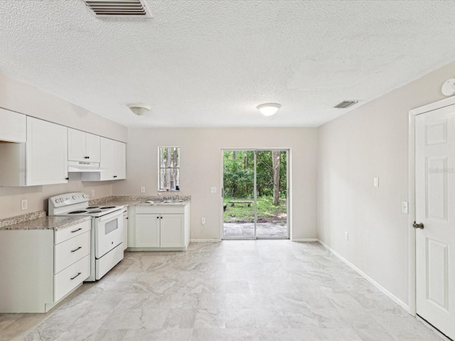 11751 Key Lime Dr, New Port Richey, FL 34654 - kitchen with white electric range oven, under cabinet range hood, white cabinetry, a textured ceiling, and light marble finish flooring