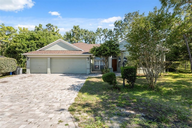 view of front of property featuring stucco siding, an attached garage, and decorative driveway