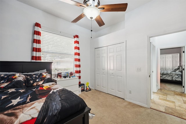 carpeted bedroom featuring baseboards, a closet, and a ceiling fan