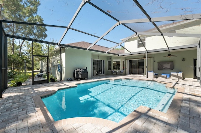 outdoor pool featuring a patio, a ceiling fan, and glass enclosure