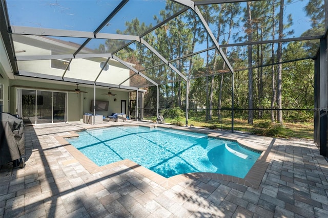 swimming pool featuring a patio area, ceiling fan, and glass enclosure
