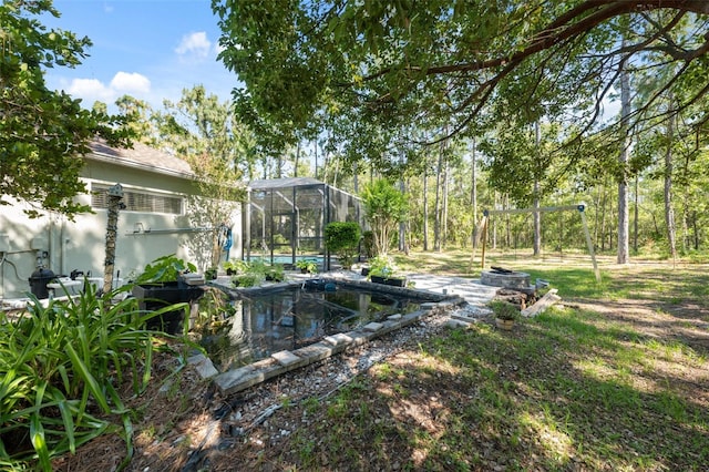 view of yard with a swimming pool and glass enclosure
