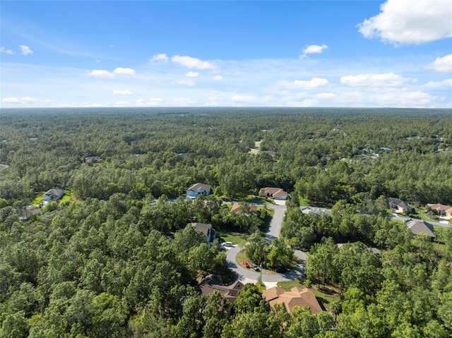 aerial view of property and surrounding area featuring a forest