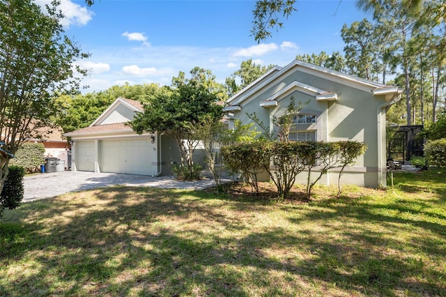 view of front facade with a front yard, a garage, driveway, and stucco siding