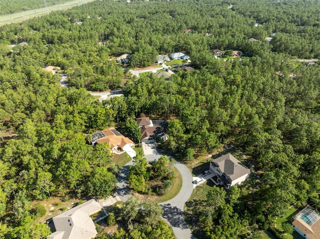 aerial view of property and surrounding area with a heavily wooded area