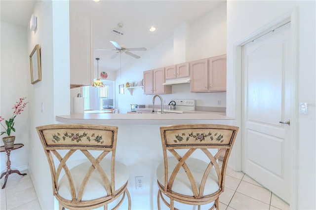11158 Heathrow Ave, Spring Hill, FL 34609 - kitchen featuring under cabinet range hood, light tile patterned flooring, ceiling fan, a peninsula, and lofted ceiling