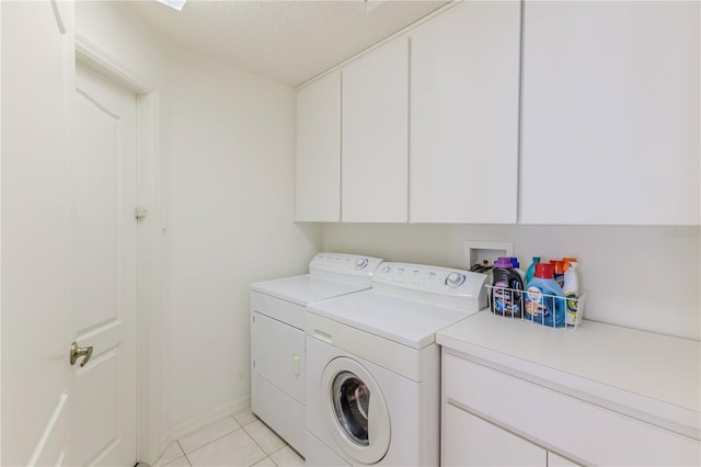 11158 Heathrow Ave, Spring Hill, FL 34609 - washroom with washing machine and dryer, cabinet space, light tile patterned flooring, a textured ceiling, and baseboards