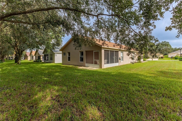 11158 Heathrow Ave, Spring Hill, FL 34609 - back of property with stucco siding, a lawn, and a sunroom
