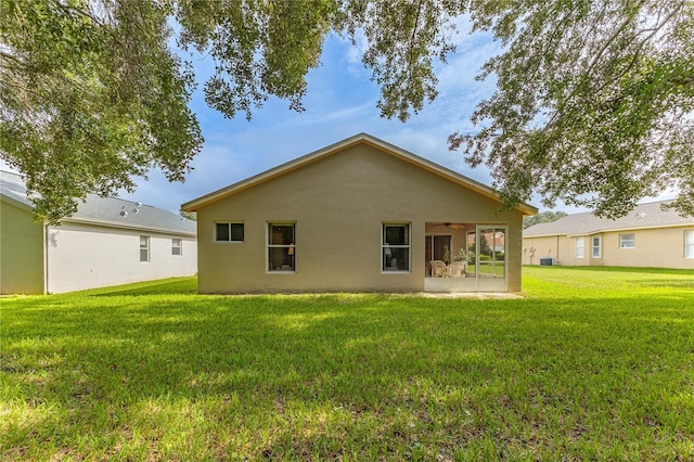 11158 Heathrow Ave, Spring Hill, FL 34609 - back of property featuring ceiling fan, a yard, a sunroom, and stucco siding