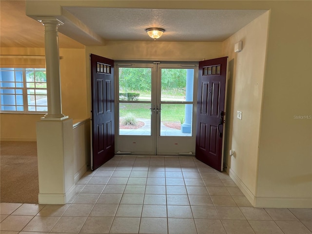 10054 Hernando Ridge Rd, Weeki Wachee, FL 34613 - entrance foyer featuring decorative columns, light tile patterned flooring, healthy amount of natural light, and a textured ceiling
