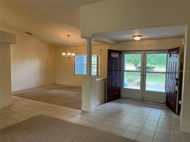 10054 Hernando Ridge Rd, Weeki Wachee, FL 34613 - foyer featuring light tile patterned flooring, light colored carpet, a chandelier, baseboards, and ornate columns