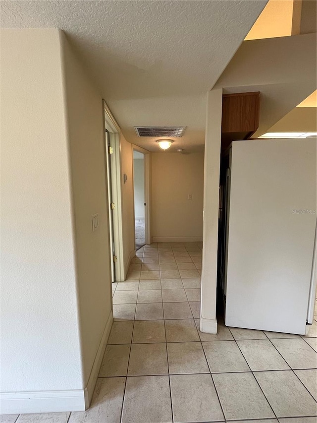 10054 Hernando Ridge Rd, Weeki Wachee, FL 34613 - hall featuring a textured ceiling, light tile patterned floors, and baseboards