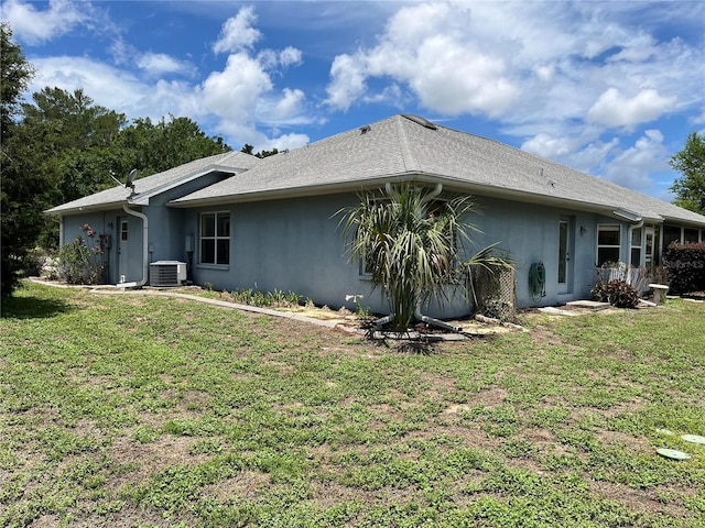 10054 Hernando Ridge Rd, Weeki Wachee, FL 34613 - back of house featuring stucco siding, a lawn, and central AC