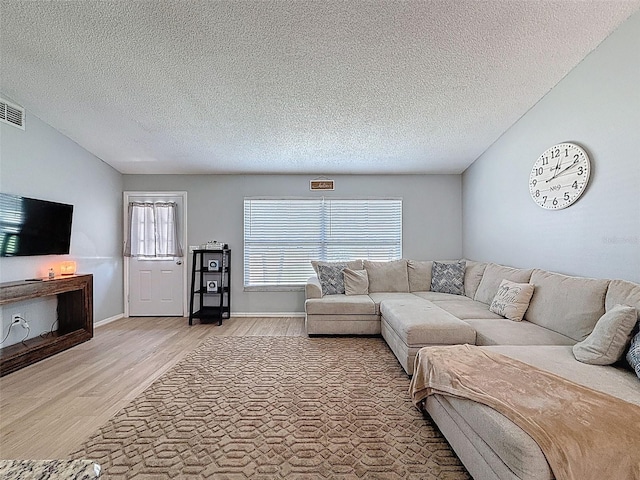 living room with light wood-style floors and a textured ceiling