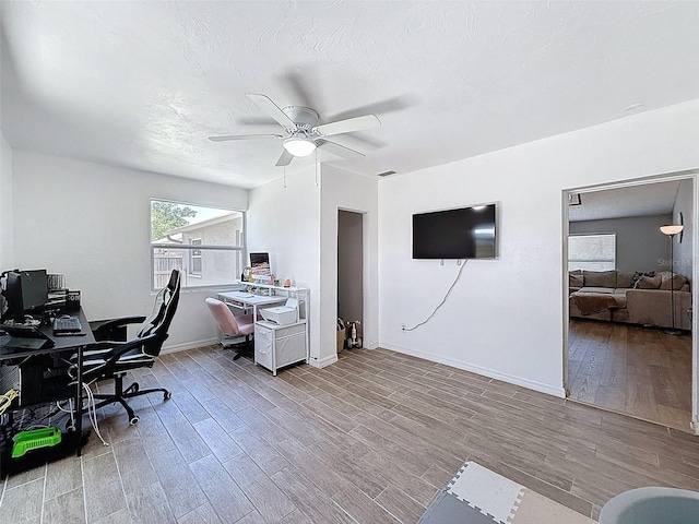 office area featuring wood finished floors, a ceiling fan, and baseboards