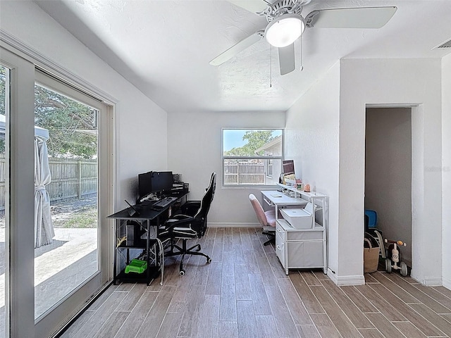 office area with wood finished floors, plenty of natural light, and ceiling fan