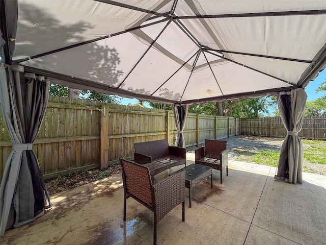 view of patio with a gazebo, a fenced backyard, and an outdoor hangout area