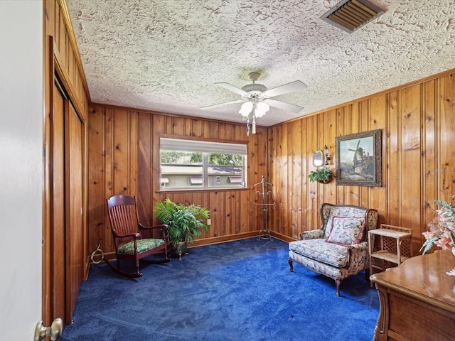 6823 Oak Hill Dr, New Port Richey, FL 34653 - living area featuring carpet flooring, wooden walls, ceiling fan, and baseboards