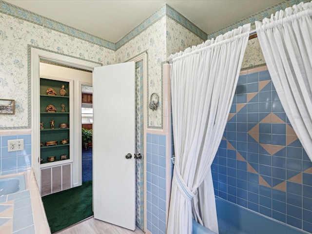 6823 Oak Hill Dr, New Port Richey, FL 34653 - full bathroom with wallpapered walls, wainscoting, shower / bathtub combination with curtain, tile walls, and wood finished floors