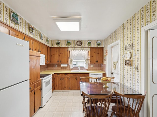 6823 Oak Hill Dr, New Port Richey, FL 34653 - kitchen with white appliances, a sink, wallpapered walls, light countertops, and light flooring