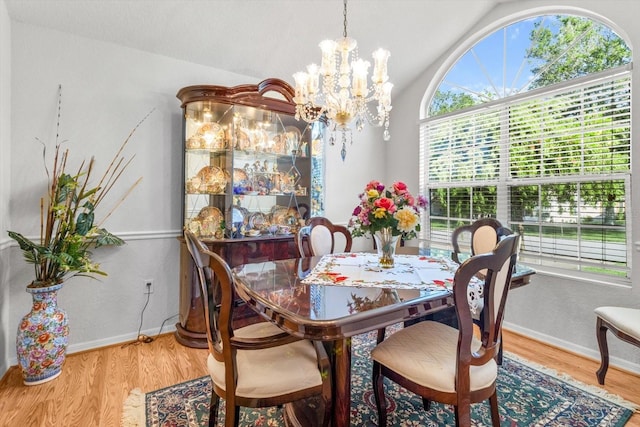 8596 SW 108th Place Rd, Ocala, FL 34481 - dining room featuring a chandelier, wood finished floors, vaulted ceiling, and baseboards