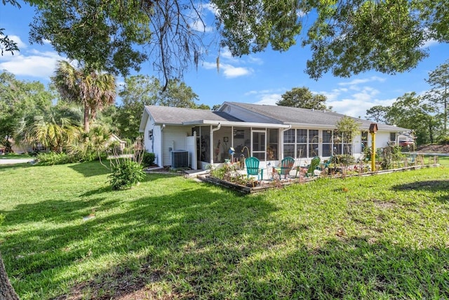 8596 SW 108th Place Rd, Ocala, FL 34481 - rear view of property with a sunroom, a yard, and central AC unit