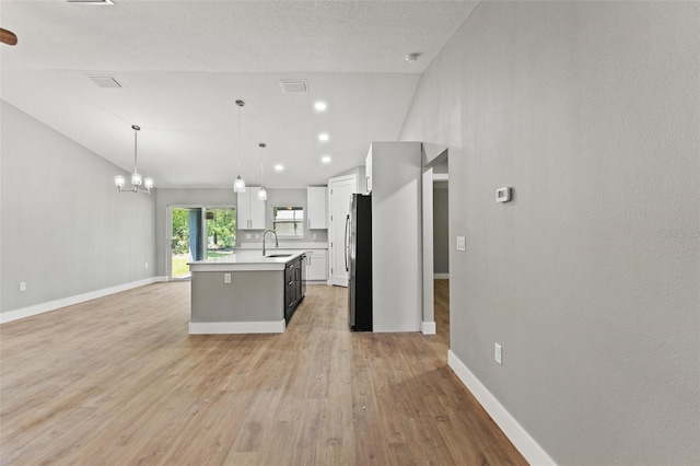 8792 N Sandree Dr, Dunnellon, FL 34434 - kitchen featuring freestanding refrigerator, light countertops, light wood-style floors, white cabinets, and a chandelier