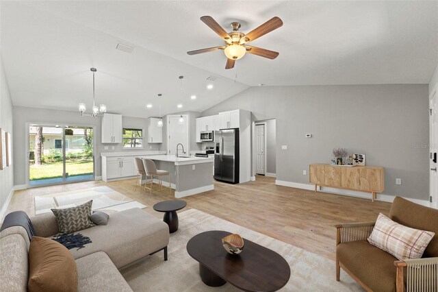 8792 N Sandree Dr, Dunnellon, FL 34434 - living area featuring lofted ceiling, light wood-type flooring, ceiling fan, a chandelier, and baseboards