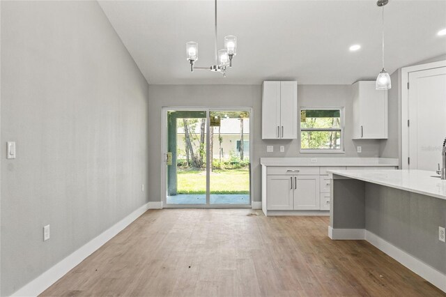 8792 N Sandree Dr, Dunnellon, FL 34434 - kitchen with light countertops, white cabinets, light wood-style flooring, baseboards, and recessed lighting