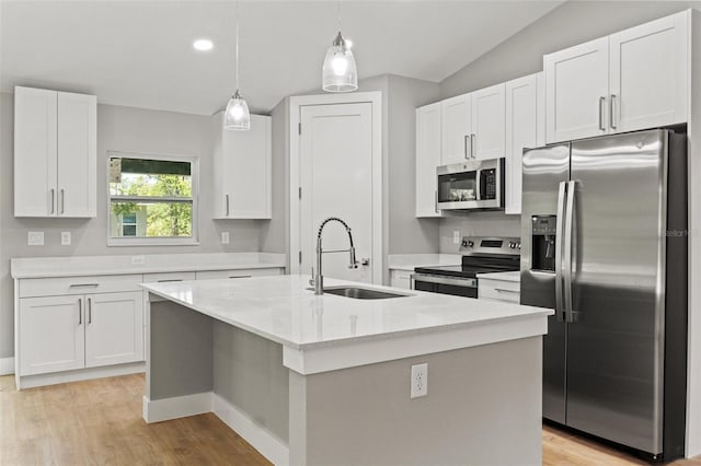 8792 N Sandree Dr, Dunnellon, FL 34434 - kitchen with appliances with stainless steel finishes, a sink, white cabinetry, light wood-style flooring, and vaulted ceiling