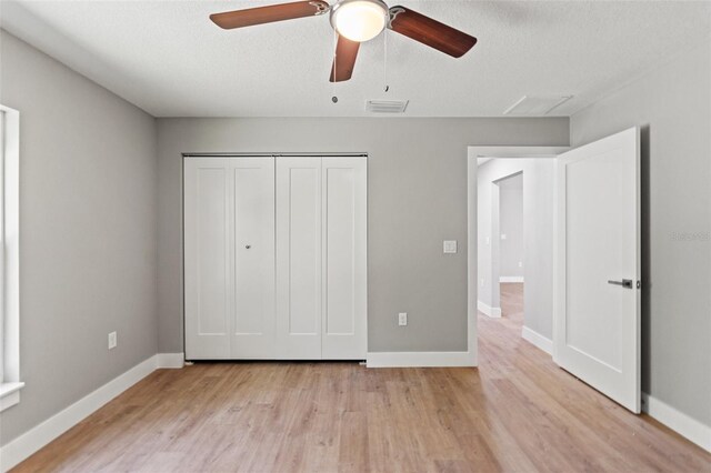 8792 N Sandree Dr, Dunnellon, FL 34434 - unfurnished bedroom with light wood-type flooring, baseboards, a closet, ceiling fan, and a textured ceiling