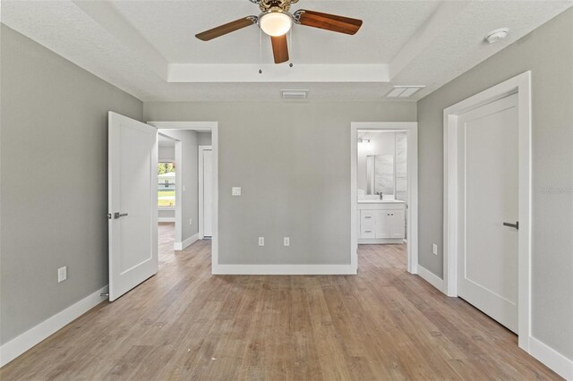 8792 N Sandree Dr, Dunnellon, FL 34434 - unfurnished bedroom with a raised ceiling, light wood finished floors, and baseboards