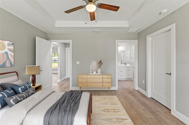 8792 N Sandree Dr, Dunnellon, FL 34434 - bedroom featuring a tray ceiling, light wood finished floors, baseboards, and a sink
