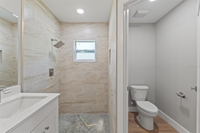 8792 N Sandree Dr, Dunnellon, FL 34434 - full bathroom with toilet, tiled shower, vanity, wood finished floors, and recessed lighting