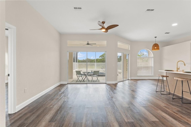 living room featuring dark wood-style floors, baseboards, and ceiling fan