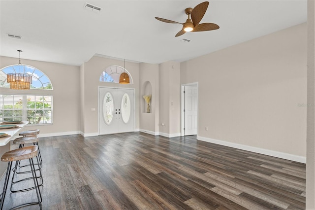 foyer with dark wood-style flooring, a chandelier, a ceiling fan, and baseboards