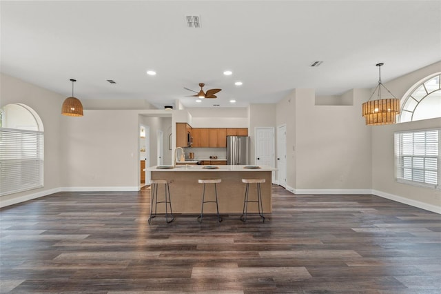 kitchen featuring freestanding refrigerator, brown cabinetry, recessed lighting, baseboards, and light countertops