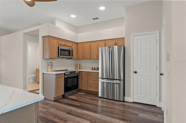 kitchen with stainless steel appliances, dark wood finished floors, light countertops, recessed lighting, and brown cabinets