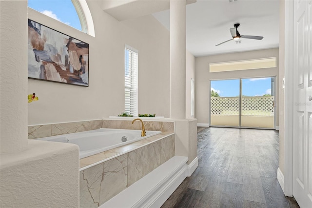 bathroom with a bath, wood finished floors, and a ceiling fan