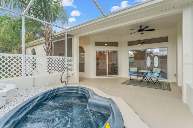 view of pool featuring an outdoor hot tub, a ceiling fan, a patio area, and a lanai