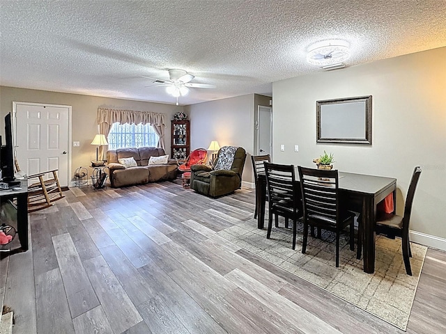 6213 Emerson Dr, New Port Richey, FL 34653 - dining room with wood finished floors, a ceiling fan, baseboards, and a textured ceiling