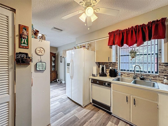6213 Emerson Dr, New Port Richey, FL 34653 - kitchen with white appliances, a sink, light wood-type flooring, decorative backsplash, and a ceiling fan