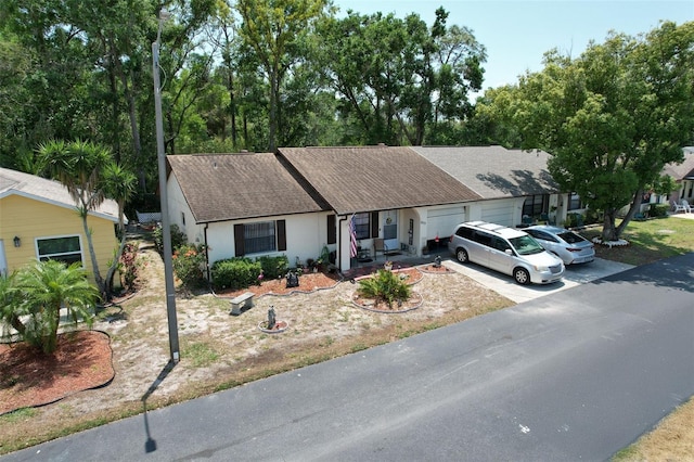 6213 Emerson Dr, New Port Richey, FL 34653 - ranch-style home with an attached garage, roof with shingles, stucco siding, and driveway
