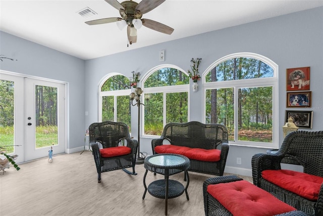 sitting room featuring wood finished floors, french doors, a ceiling fan, and baseboards