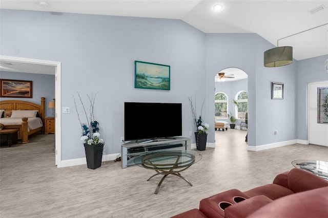 living area with wood finished floors, baseboards, high vaulted ceiling, and a ceiling fan