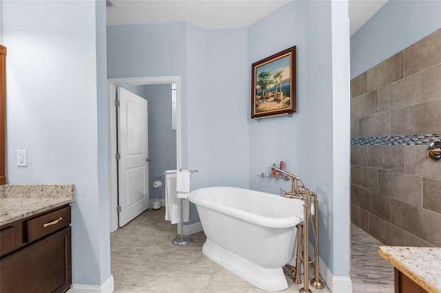 full bathroom featuring a walk in shower, a freestanding bath, wood finished floors, and baseboards