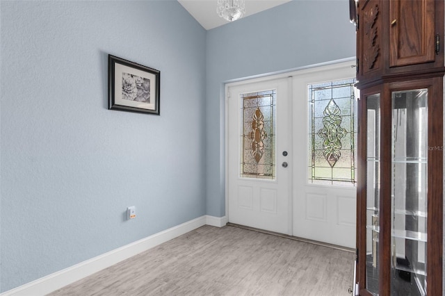 entrance foyer featuring light wood-style flooring, baseboards, and a chandelier