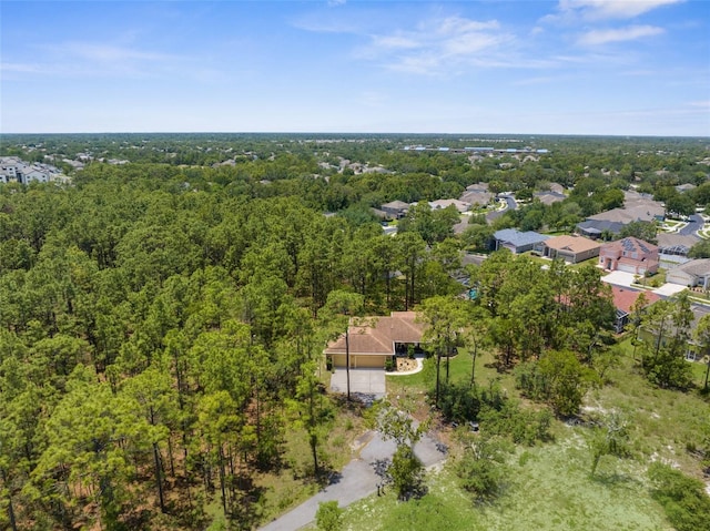 aerial view of property and surrounding area featuring a forest